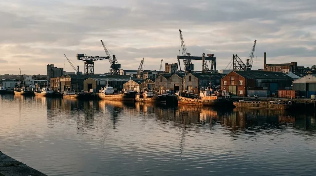 Plymouth commercial harbour with dry-dock cranes at low afternoon light representing Aristral's digital marketing work for Plymouth's maritime and B2B businesses